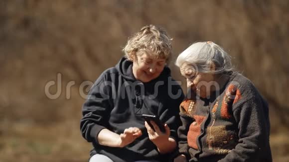 一个女人教她的老母亲使用智能手机两个女人看智能手机图片的肖像视频的预览图