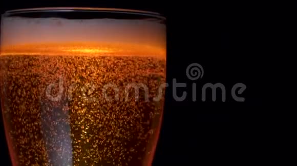 在装有水滴的大玻璃杯中加入许多冷却啤酒的气泡视频的预览图