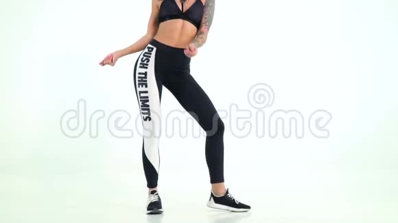穿着黑色运动服在白色背景下跳舞的年轻女士视频的预览图