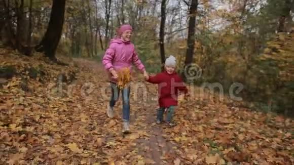 欢乐的孩子们穿过秋天的林地视频的预览图