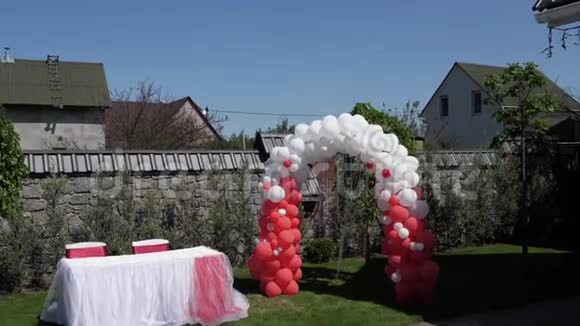 红白气球做成的婚礼拱门婚礼仪式视频的预览图