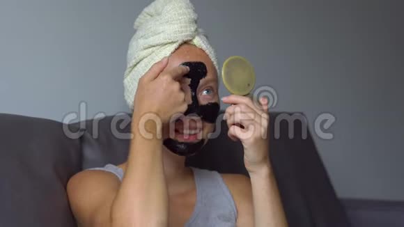 一个漂亮的年轻女人用手提式的照片戴上黑色的面罩视频的预览图