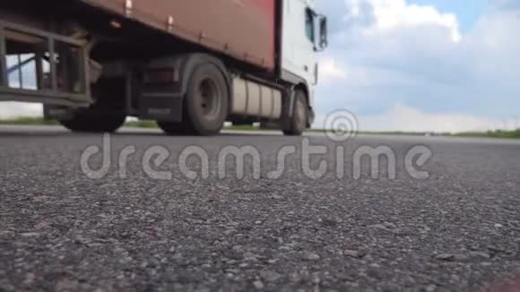在阳光明媚的夏日两辆卡车在空高速公路上行驶的低角度视图货运半卡车视频的预览图