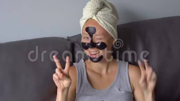 一张戴着黑脸面具的漂亮年轻女子的手持照片视频的预览图