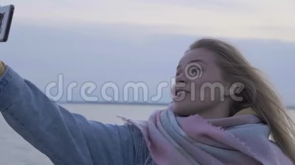 年轻女子在秋日海滩打电话自拍视频的预览图