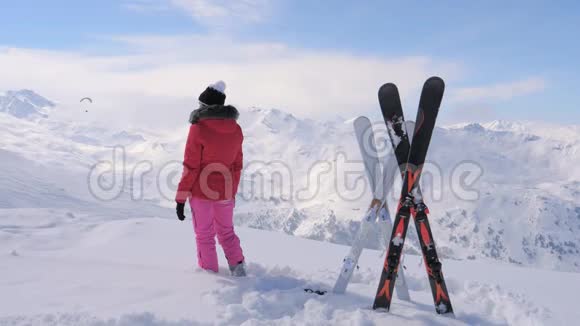 女滑雪者站在山顶望着远处视频的预览图