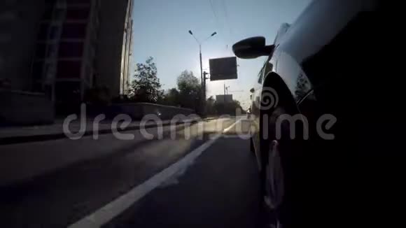 汽车在日落时沿着城市街道行驶视频的预览图
