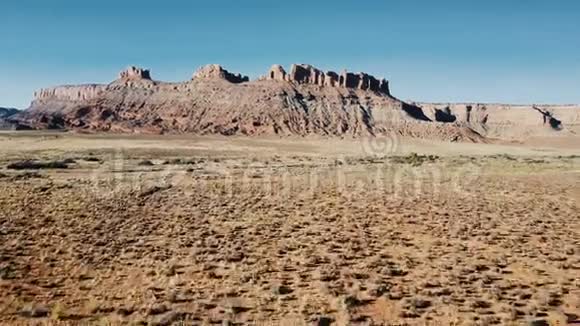 在美国国家公园里无人机飞过干燥的砂岩沙漠飞向令人惊叹的平顶山和清澈的蓝天视频的预览图