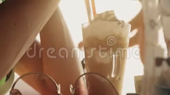 在阳光明媚的夏日里一位美丽的女士在吃冰冷奶昔视频的预览图