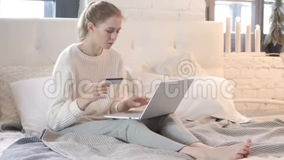 坐在床上的年轻女子网上购物视频的预览图
