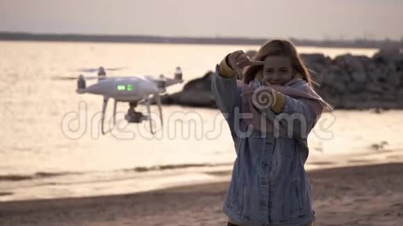 日落海边快乐的女孩用无人机拍摄视频视频的预览图