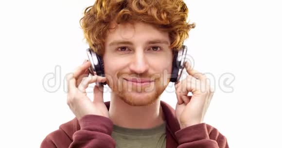 美丽快乐有趣的年轻成年红发男子听音乐使用耳机和舞蹈个人行动视频视频的预览图