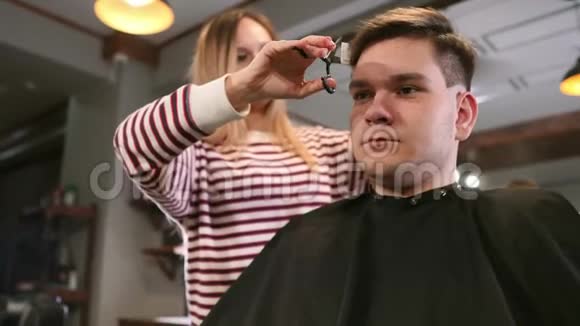 现代理发店工作过程的内部镜头时尚发型的迷人年轻人的侧视画像视频的预览图