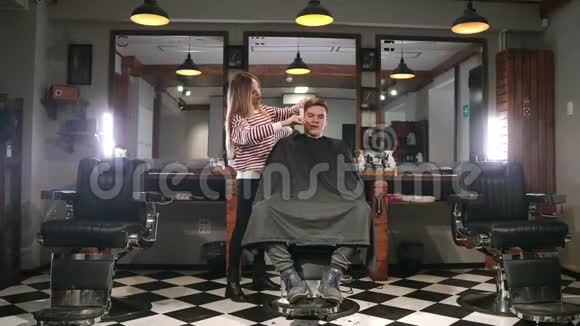 现代理发店工作过程的内部镜头时尚发型的迷人年轻人的侧视画像视频的预览图