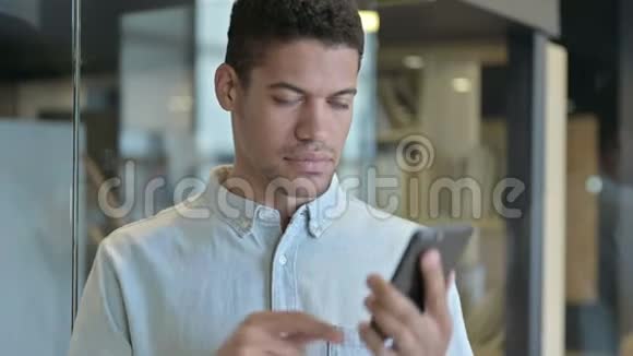 英俊的非洲男人在智能手机上说话视频的预览图