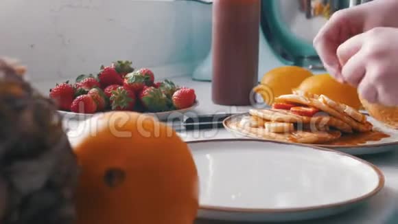 一个女人在煎饼上放甜草莓视频的预览图