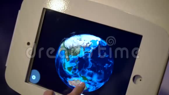 一个人触摸平板电脑并绕着地球模型运行的慢动作镜头天文博览会视频的预览图
