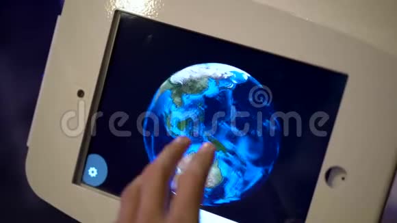 一个人触摸平板电脑并绕着地球模型运行的慢动作镜头天文博览会视频的预览图
