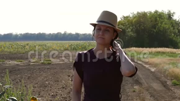 一个戴着帽子的年轻女农民穿过田野农业的概念视频的预览图