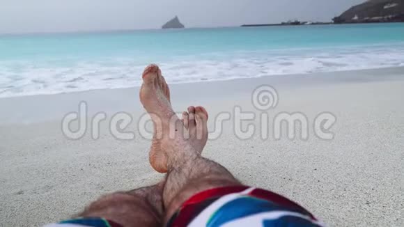 他的脚踩在沙滩上度假放松理念沙滩度假背景4k视频视频的预览图