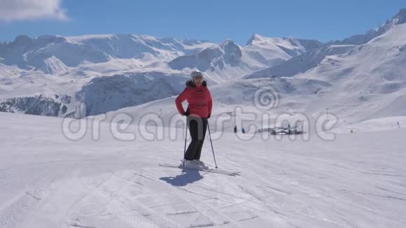 运动女滑雪者站在滑雪场的斜坡上视频的预览图