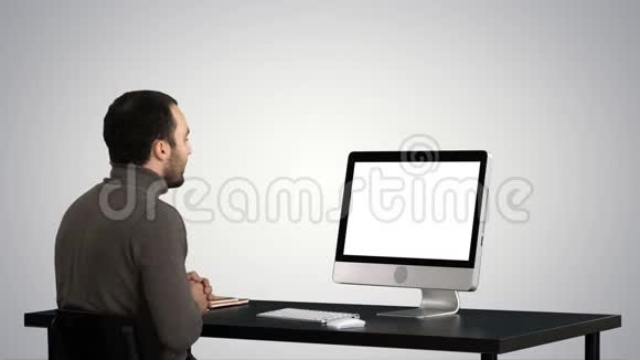 年轻的商人在梯度背景下的电脑上打视频电话视频的预览图