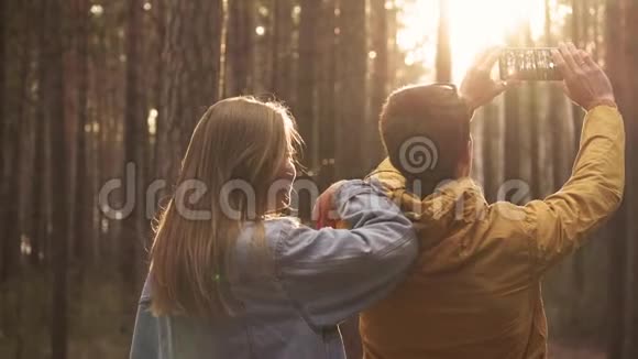 年轻人和女人在森林里打电话拍照视频的预览图