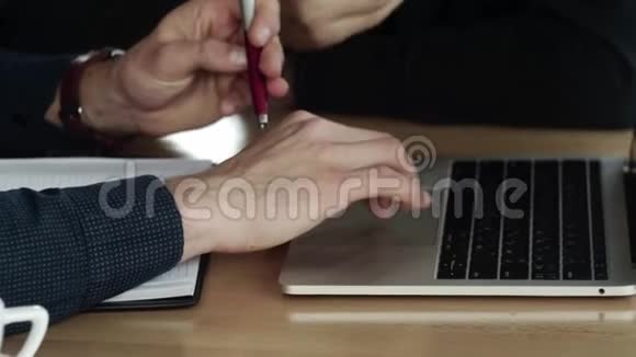 商人的双手在咖啡馆里坐在木桌旁可以看到一个在笔记本电脑上工作的人讨论视频的预览图