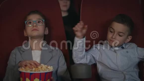 孩子们在电影院吃爆米花学龄前儿童看电影视频的预览图