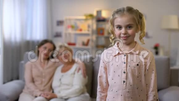 微笑的女孩在镜头里看着母亲和奶奶的背景几代人视频的预览图
