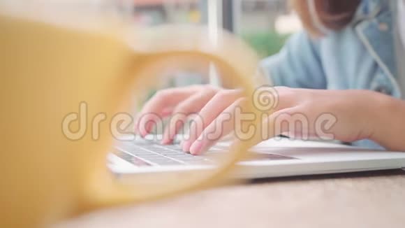 商业自由职业的亚洲女性工作在笔记本电脑上做项目在咖啡馆里坐在桌子上喝着温暖的咖啡视频的预览图