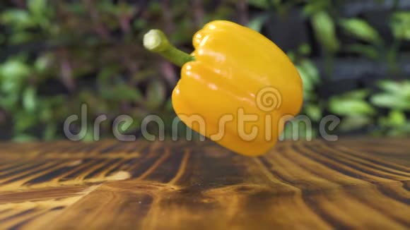黄铃椒落在木桌上慢动作蔬菜落在厨房桌子上关闭食物背景视频的预览图