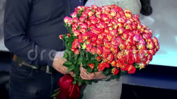 和丈夫在一起的女孩捧着一大束粉色玫瑰未来新娘盛宴的概念视频的预览图