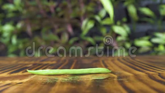 法式绿豆在木桌背景上飘落滚动快关门新鲜蔬菜背景素食视频的预览图