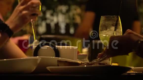 朋友在餐馆吃牛排喝葡萄酒盘子和手的特写镜头视频的预览图
