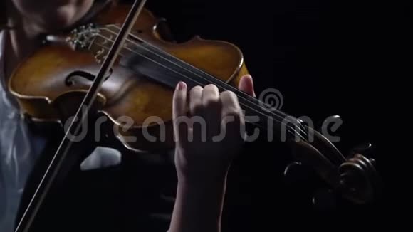 小提琴手持弓演奏黑色背景关门视频的预览图