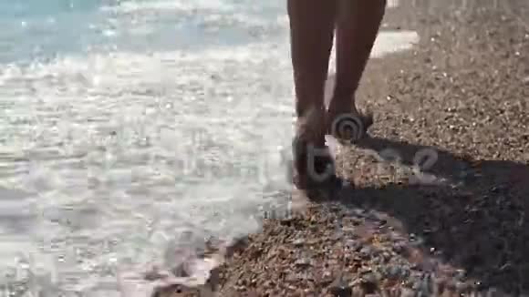 穿着拖鞋鞋在海滩上行走的女足视频的预览图