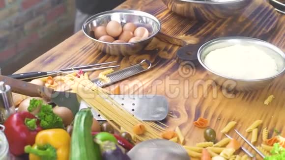 厨房餐桌上的食物配料在木桌上做菜用的鸡蛋面粉和新鲜蔬菜意大利视频的预览图