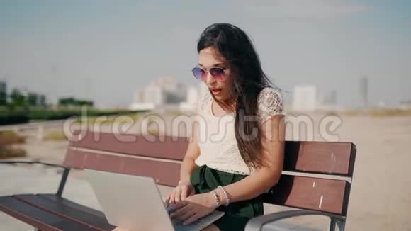 快乐的年轻女子在笔记本电脑上工作成功视频的预览图