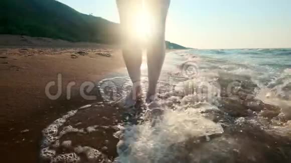 女孩沿着水边走女人在沙滩上沿着海岸走摄像机在追女性视频的预览图