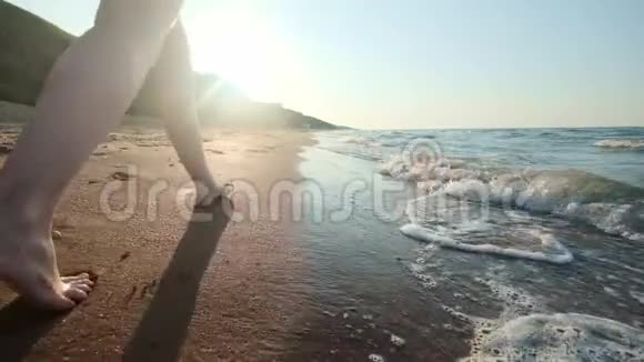 女孩沿着水边走女人在沙滩上沿着海岸走摄像机在追女性视频的预览图