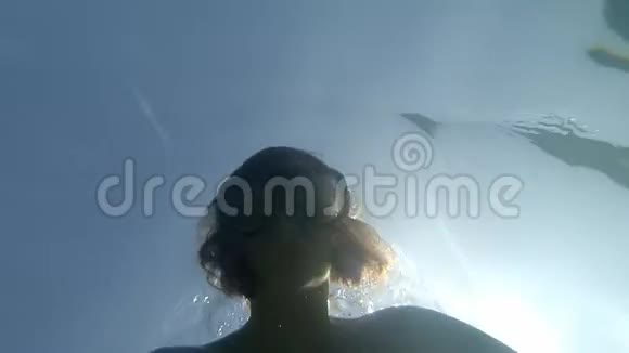 年轻的棕色头发的女人带着游泳面具看着动作镜头在水下潜水没有角鲨鱼的灯光视频的预览图