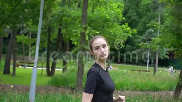 一位年轻的美女在夏天独自在公园里跑步视频的预览图