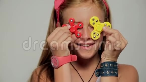年轻女孩拿着流行的坐立不安的旋转玩具特写肖像视频的预览图