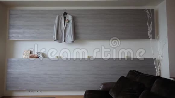 新郎结婚前一个男人把挂在卧室里的夹克挂在衣架上视频的预览图