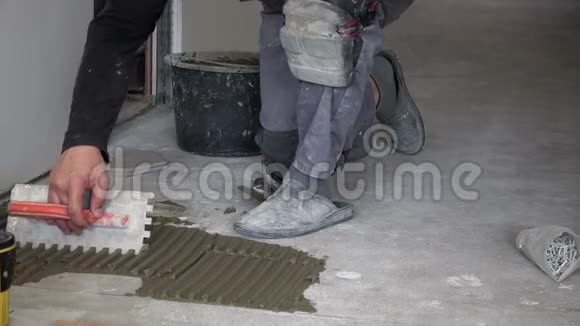 人在地板上涂胶水泥铺六角瓷砖视频的预览图