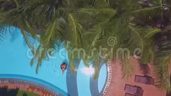 女人在游泳池的浮标上航行阳光反射视频的预览图
