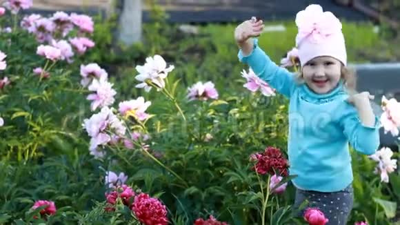 小女孩正在花园里编舞着牡丹幸福和童年的概念视频的预览图