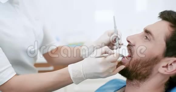 牙科医生口腔检查时张口的年轻男性视频的预览图