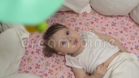 小孩子躺在摇篮里看着旋转的玩具视频的预览图